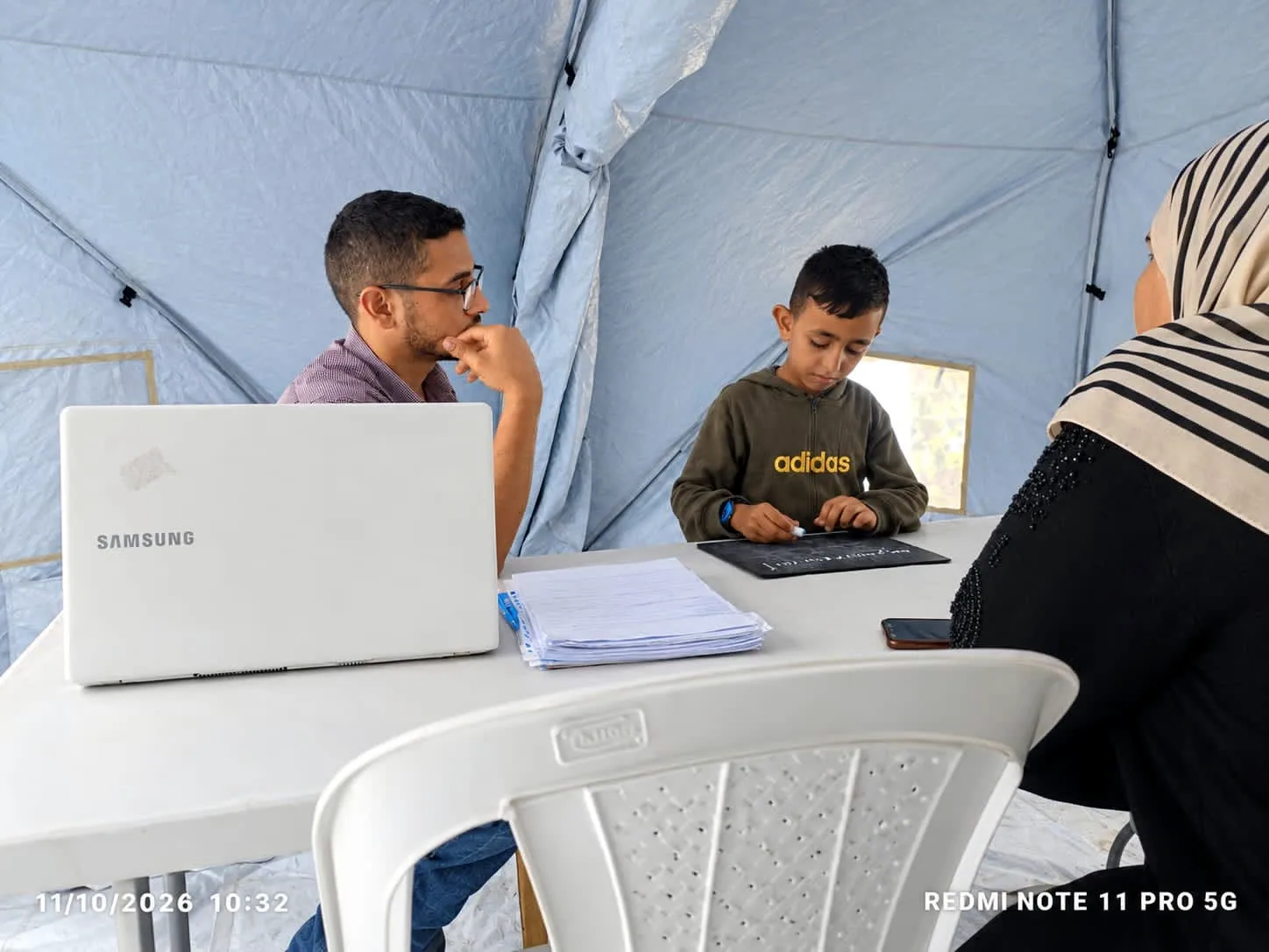 مجموعة أشخاص يجلسون حول طاولة مع أوراق وأجهزة