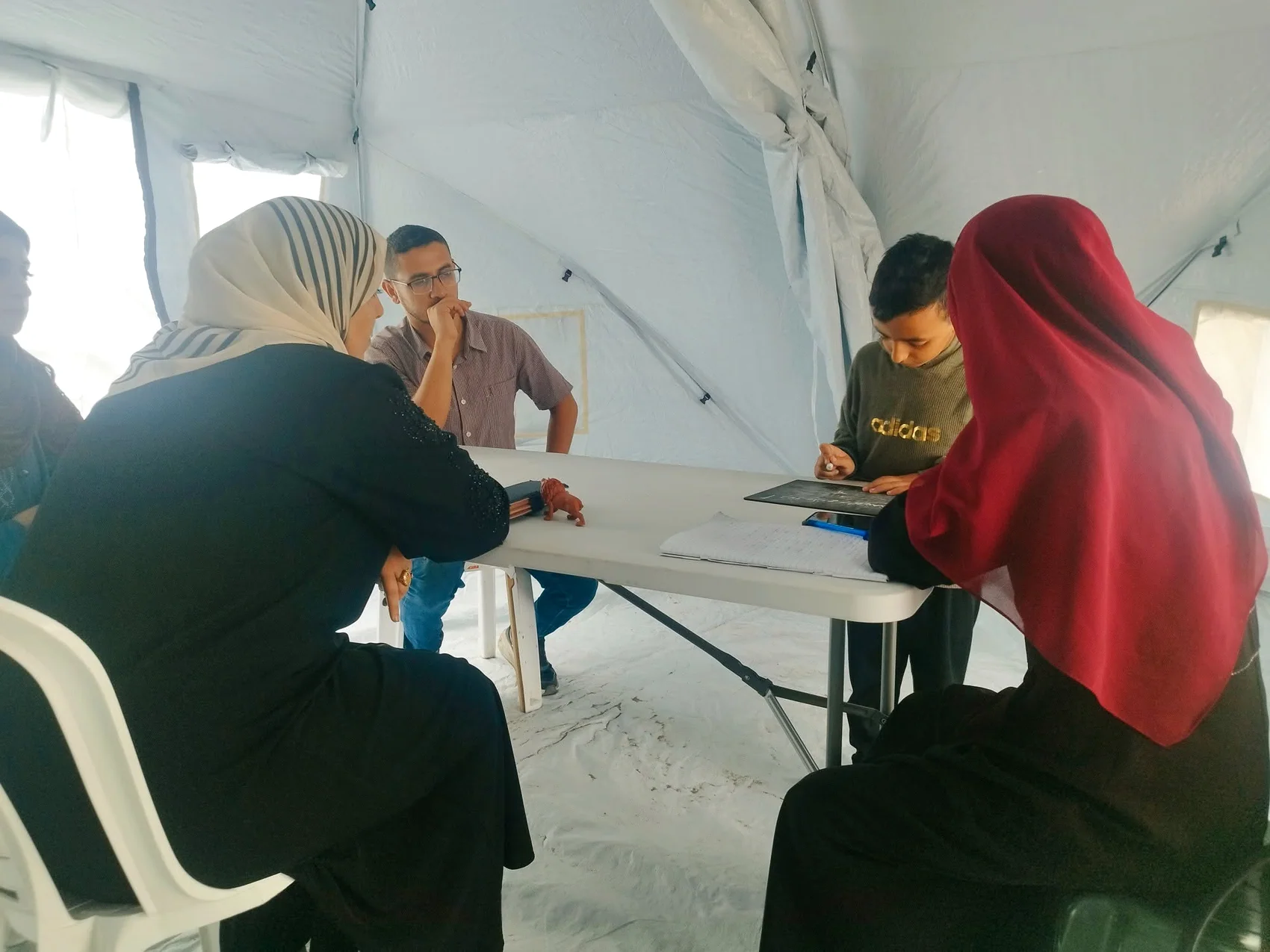 مجموعة من الأشخاص حول طاولة يتابع أحدهم مادة مكتوبة